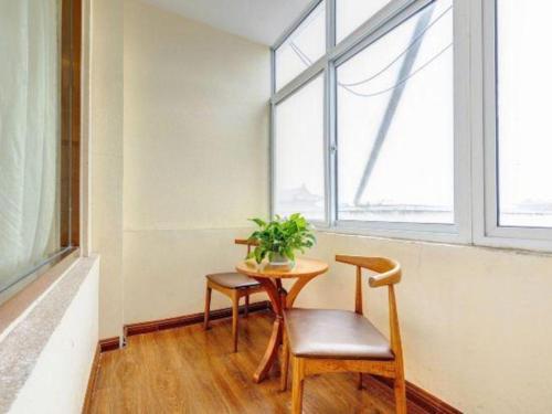 a table and chair in a room with a window at James Joyce Coffetel Qufu Tourist Center Gulou Street Sankong Scenic Spot in Jining