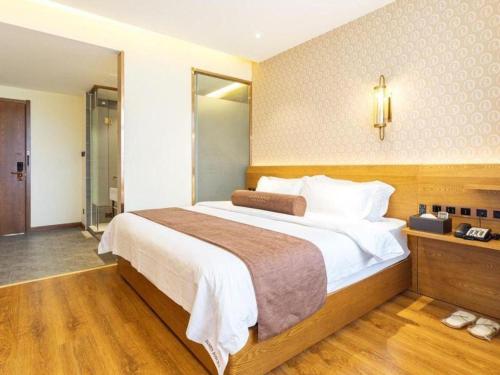 a bedroom with a large bed in a room at James Joyce Coffetel Qufu Tourist Center Gulou Street Sankong Scenic Spot in Jining