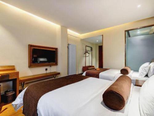 a hotel room with two beds and a television at James Joyce Coffetel Qufu Tourist Center Gulou Street Sankong Scenic Spot in Jining