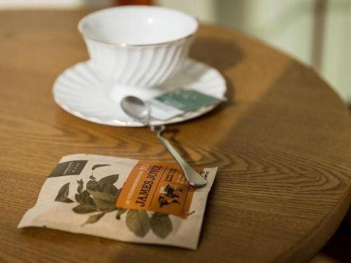 a table with a plate and a cup and a spoon at James Joyce Coffetel Qufu Tourist Center Gulou Street Sankong Scenic Spot in Jining