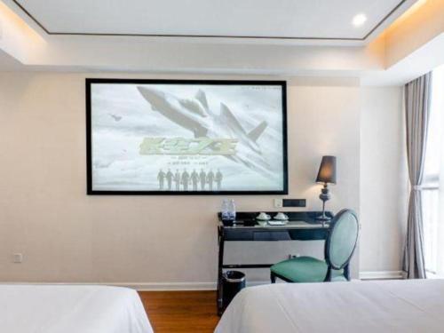 a room with two beds and a large screen at Xana Lite Anqing Yuexi Swan Squre Branch in Yuexi