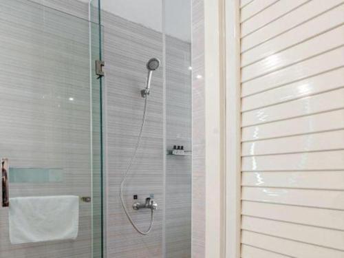 a shower with a glass door in a bathroom at Xana Lite Anqing Yuexi Swan Squre Branch in Yuexi