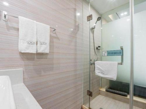 a bathroom with a shower with towels hanging on a wall at Xana Lite Anqing Yuexi Swan Squre Branch in Yuexi