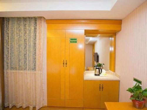 cocina con armarios de madera, lavabo y espejo en Vienna 3 Best Hotel Jiangsu Suzhou Zhouzhuang Luzhi Ancient Town, en Suzhou