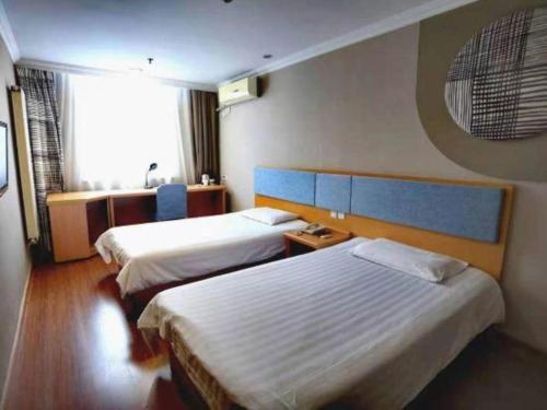 a hotel room with two beds and a window at Home Inn-Qingdao Chongqing Zhong Road Licang Walking Street in Laoshan