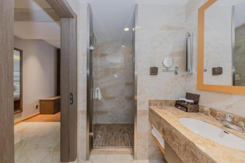 a bathroom with a sink and a shower at Yitel Shanghai Hongqiao Railway Station National Convention and Exhibition Center in Fangjiayao