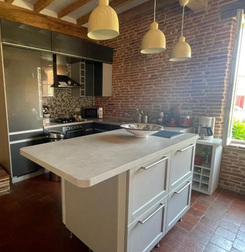 une cuisine avec un grand îlot au milieu dans l'établissement Grand gîte du château, à Montlaur