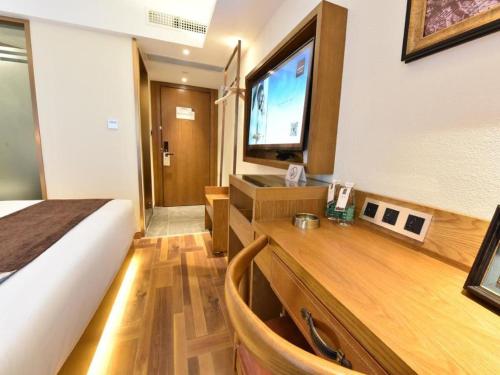 a hotel room with a bed and a television at James Joyce Coffetel·Chengdu Chunxi in Chengdu