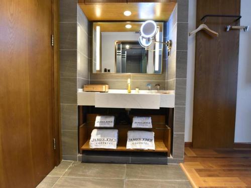a bathroom with a sink and a mirror at James Joyce Coffetel·Chengdu Chunxi in Chengdu