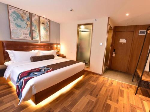 a bedroom with a large bed and a wooden floor at James Joyce Coffetel·Chengdu Chunxi in Chengdu