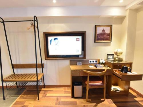 a room with a desk and a television on a wall at James Joyce Coffetel·Chengdu Chunxi in Chengdu