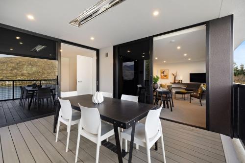 a dining room and living room with a table and chairs at The Bunker Alpha B in Queenstown