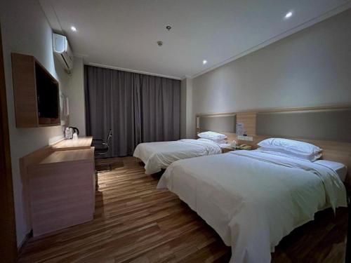 Giường trong phòng chung tại City Comfort Inn Wuhan Jiangxia Stadium