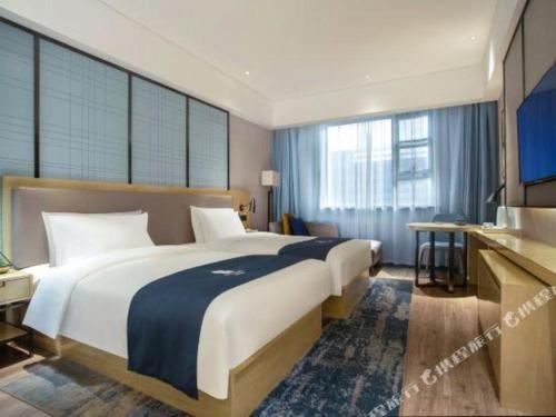 a bedroom with a large bed and a large window at Echarm Hotel Jingjiang Bus Passenger Station Fanggu Street in Jingjiang