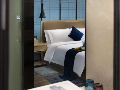 a bedroom with a bed and a nightstand with a bed sidx sidx sidx at Echarm Hotel Jingjiang Bus Passenger Station Fanggu Street in Jingjiang
