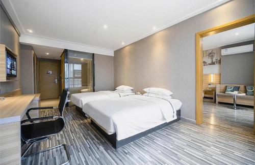 a bedroom with a large white bed and a desk at City Comfort Inn Lichuan Railway Station Tenglong Cave in Enshi