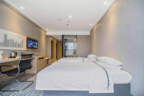 a bedroom with a large white bed and a desk at City Comfort Inn Lichuan Railway Station Tenglong Cave in Enshi