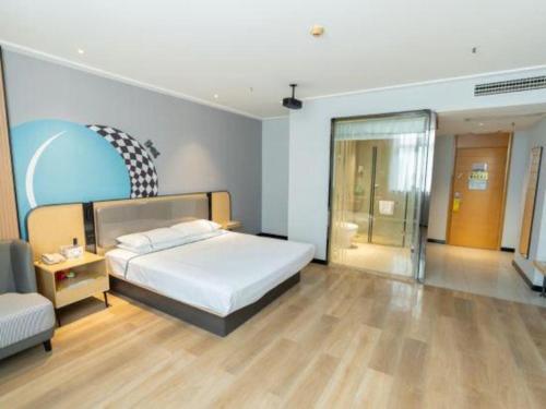 a bedroom with a bed and a sliding glass door at City Comfort Inn Yingcheng Railway Station Shanghe Square in Xiaogan