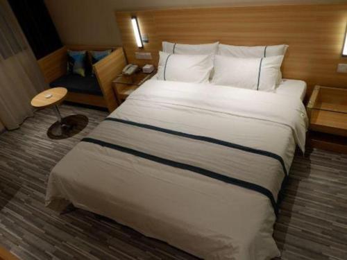 a large white bed in a hotel room at City Comfort Inn Yingcheng Railway Station Shanghe Square in Xiaogan
