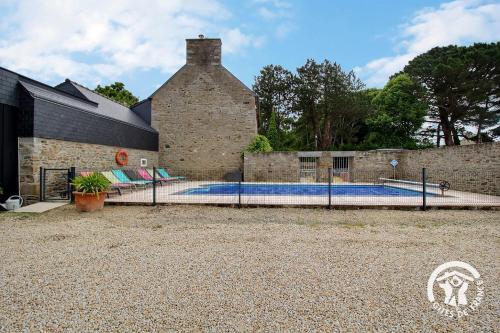 une piscine devant un bâtiment en briques dans l'établissement Bouton d'or, à Pordic