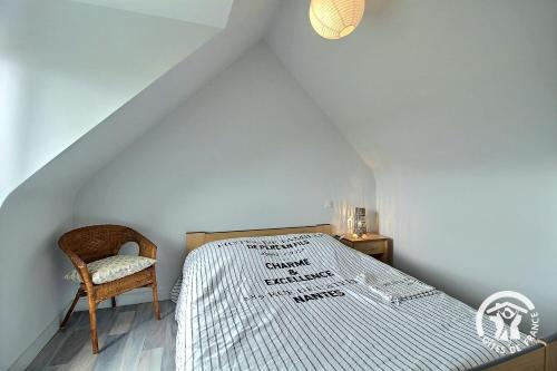 une chambre avec un lit et une chaise dans l'établissement Bouton d'or, à Pordic