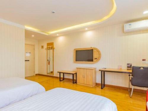 a hotel room with two beds and a television at PAI Hotels Shijiazhuang Railway Station West Square in Shijiazhuang