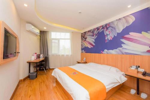 a bedroom with a large bed with a painting on the wall at PAI Hotels Shijiazhuang Railway Station West Square in Shijiazhuang