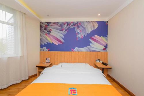 a bedroom with a bed and a painting on the wall at PAI Hotels Shijiazhuang Railway Station West Square in Shijiazhuang