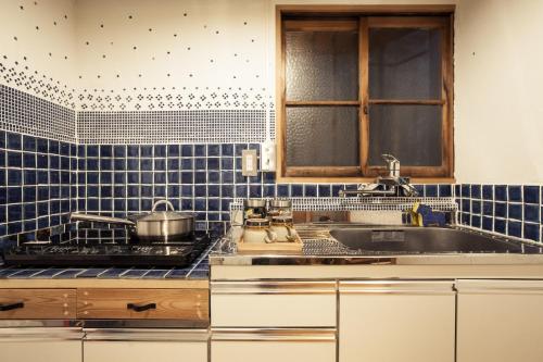a kitchen with blue tiled walls and a sink at Araiya Tokyo -Private Townhouse- in Tokyo