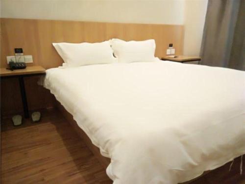 a large white bed in a hotel room at PAI Hotels Shijiazhuang Railway Station West Square in Shijiazhuang