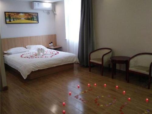 a bedroom with a bed with red candles on the floor at PAI Hotels Shijiazhuang Railway Station West Square in Shijiazhuang