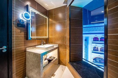 ein Badezimmer mit Waschbecken und Dusche in der Unterkunft Xana Hotelle Tianjin Binjiang Road Heping Road Metro Station Quanyechang in Tianjin