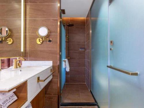 a bathroom with a shower and a sink and a mirror at James Joyce Coffetel Lijiang Ancient City Dashuiche in Lijiang
