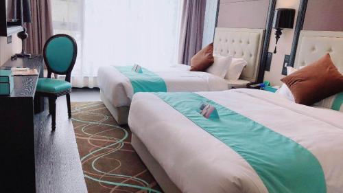 a hotel room with two beds and a chair at Xana Hotelle Xi'an Zhonglou, Huimin Street Metro Station in Xi'an