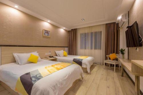 a hotel room with two beds and a television at Shell Hotel Shanghai Oriental Pearl Tower Century Avenue Metro Station in Shanghai