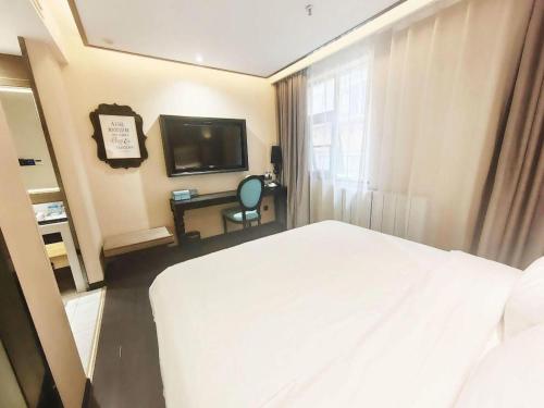 a hotel room with a bed and a television at Xana Hotelle Xi'an Zhonglou, Huimin Street Metro Station in Xi'an