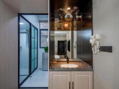 a bathroom with a sink and a mirror at Shell Hotel Shanghai Oriental Pearl Tower Century Avenue Metro Station in Shanghai
