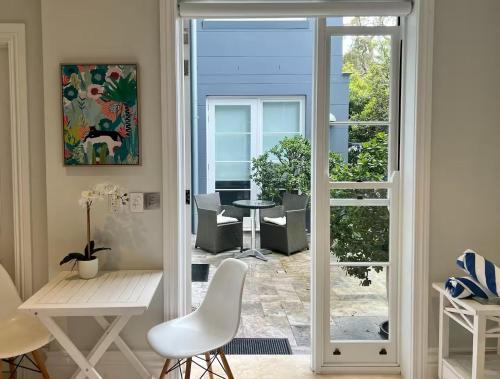 an open door to a patio with a table and chairs at Balmoral Salt in Sydney