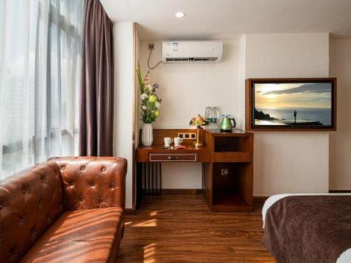 a hotel room with a couch and a desk at James Joyce Coffetel Guilin Railway Station Xiangbi Mountain Liangjiang Sihu Wharf in Guilin