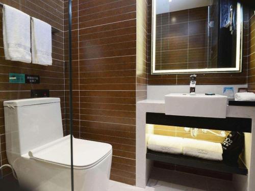 a bathroom with a toilet and a sink at Xana Hotelle Xi'an Zhonglou, Huimin Street Metro Station in Xi'an