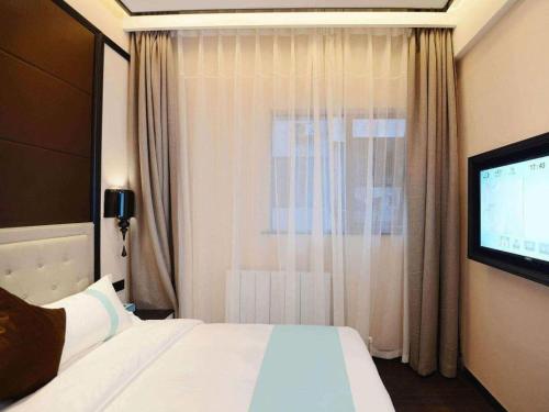 a hotel room with a bed and a flat screen tv at Xana Hotelle Xi'an Zhonglou, Huimin Street Metro Station in Xi'an