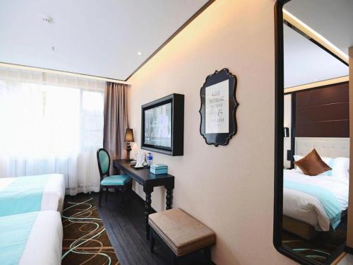 a hotel room with a bed and a desk with a mirror at Xana Hotelle Xi'an Zhonglou, Huimin Street Metro Station in Xi'an