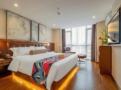 a hotel room with a large bed and a television at James Joyce Coffetel Guilin Railway Station Xiangbi Mountain Liangjiang Sihu Wharf in Guilin