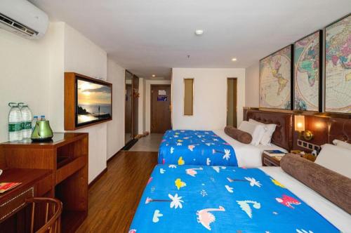a hotel room with two beds and a desk at James Joyce Coffetel Guilin Railway Station Xiangbi Mountain Liangjiang Sihu Wharf in Guilin