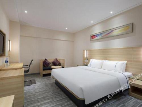 a hotel room with a large bed and a television at City Comfort Inn Changsha Window of the World Zhongmao City in Changsha