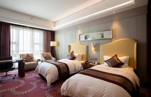 a hotel room with two beds and a piano at Bairun Zhenjiang International Hotel in Zhenjiang