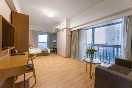 a living room with a couch and a large window at VX Hotel Wuxi Xinwu District Executive Center Wanda Plaza in Wuxi
