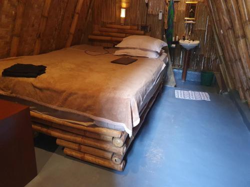 a bedroom with a bed made out of logs at the bamboo Bali Cabin in Nusa Dua