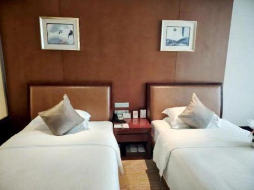 a hotel room with two beds and a table at Balan International Hotel in Dujiangyan