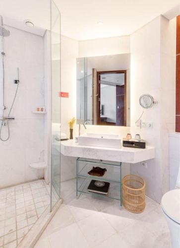 a white bathroom with a tub and a sink at Balan International Hotel in Dujiangyan